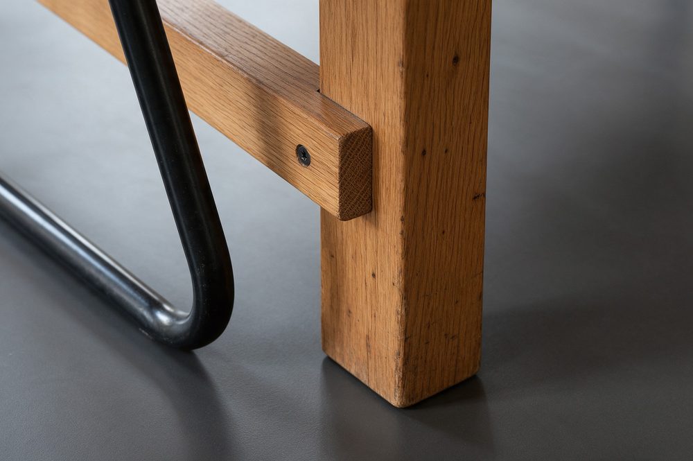 antraciet gietvloer met eikenhouten tafel en betonnen wand